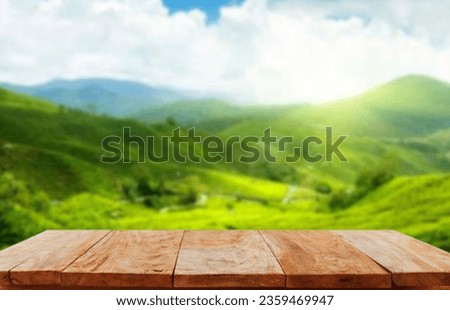 Wooden table top on blur green tea mountain and grass field.Fresh and Relax concept.For montage product display or design key visual layout.View of copy space.