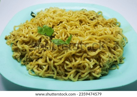Indomie Goreng Instant Fried Noodles Popular in Indonesia. Front view of fried noodles served with celery