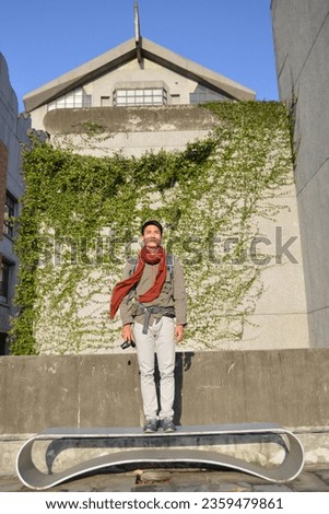 Asian young photographer taking picture with professional camera outdoors