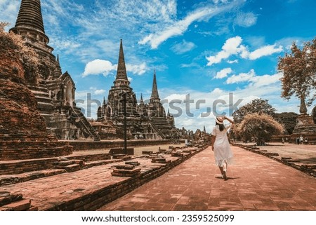 Historical local travel Thai concept, Happy traveler asian woman with dress sightseeing in Wat Phra Si Sanphet temple with pagoda background, Ayutthaya historical park, Ayutthaya, Thailand Royalty-Free Stock Photo #2359525099
