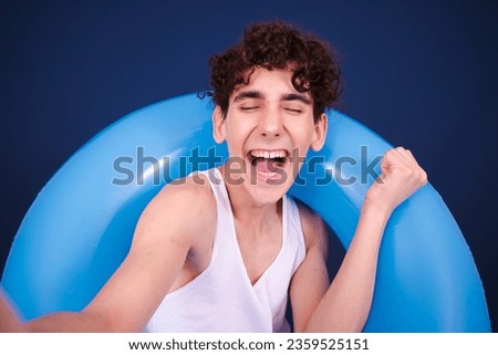 Summer and holidays. A young attractive guy posing in the studio with an inflatable ring.