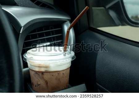Ice coffee with plastic cup in the car cup holder. coffee on the road while driving.espresso,latte,cappuccino,arabica,ice cocoa