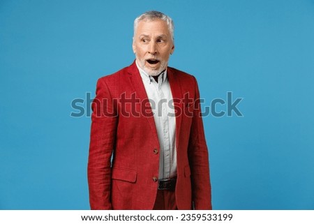 Shocked amazed surprised elderly gray-haired mustache bearded business man wearing red jacket suit standing keeping mouth open looking aside isolated on blue color wall background studio portrait Royalty-Free Stock Photo #2359533199