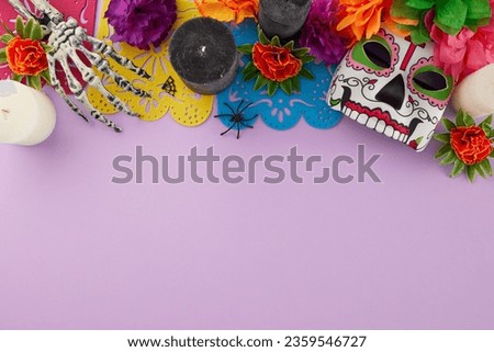 Join the festive spectacle of Dia de los Muertos. Top view shot of traditional mask, elaborate flowers, colorful garland, candle, skeleton arm, scary decor on lilac background with ad area