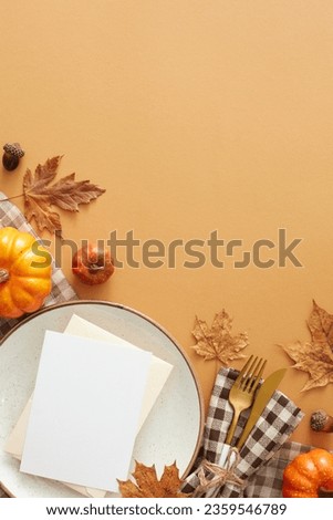Thanksgiving gathering idea. Top view vertical shot of postcard, plate, cutlery, tablecloth, colorful pumpkins, acorns, dry leaves on pastel brown background with promo spot