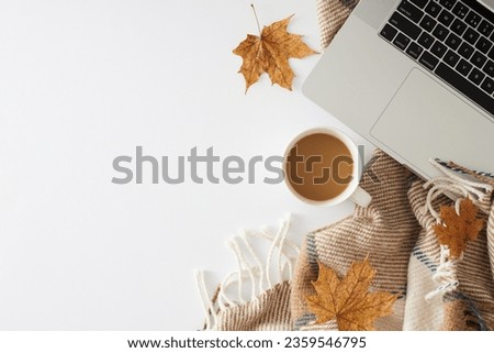Fall-themed workspace concept. Top view photo of trendy cozy plaid, cup of coffee, notepad, autumn leaves on white background with promo zone