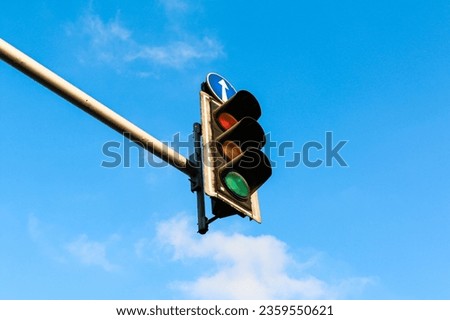 Vibrant traffic light against a clear blue sky, highlighting urban elements in a natural backdrop. Isolated. Ideal for diverse creative urban projects.
