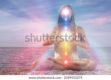 Yoga meditation outdoors. Glowing seven all chakra. Woman sits in a Upward Salute pose on beach sunset view, Kundalini energy. girl practicing. Royalty-Free Stock Photo #2359553275