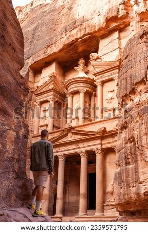 Rear view of man in spectacular view of Al Khazneh (The Treasury), ancient city of Petra, Jordan Royalty-Free Stock Photo #2359571795