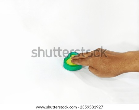someone's hand is using a fingertip made of foam and plastic on a white background