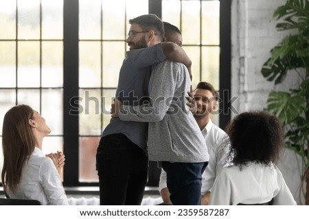 Happy male stand hug show support and help, participate in group psychological session together, supportive people drug alcohol addicts comfort empathize, take part in team counseling therapy Royalty-Free Stock Photo #2359587287