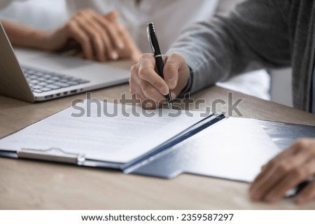Close up of male employee put signature on paper document close deal after successful interview in office, candidate sign paperwork contract make agreement at meeting, recruitment concept