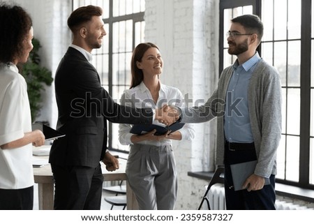 Happy male business partners shake hands get acquainted greeting in office, smiling businessmen handshake close deal or make agreement after successful negotiation, partnership concept Royalty-Free Stock Photo #2359587327