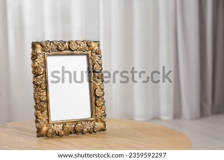 Empty photo frame on wooden table, space for text