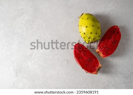 Prickly pears, exotic cactus fruits cut in halves, top view. Copy space Royalty-Free Stock Photo #2359608191
