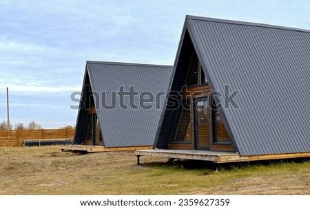 Wooden houses in a triangular summer camp. summer vacation in an eco-friendly house, summer Royalty-Free Stock Photo #2359627359