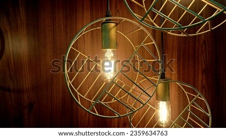 Pictures of the frame are kept inside the house. There is a circle of metal decorations and swirly yellow lights with a brown wood background.