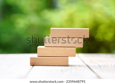 4 stacking rectangle empty wooden blocks on table with green natural blur background for own customer text or letters. Idea of environment, energy or business concept. Front view, banner copy space.