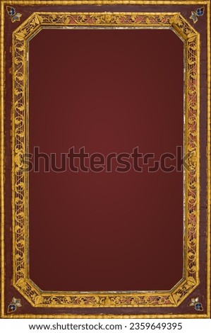 A delicately carved wooden picture frame painted in gold with a dark red background isolate frame with path.