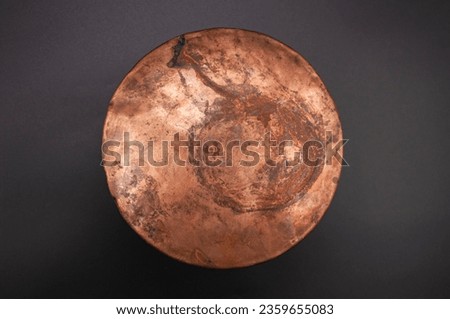 Detailed photo of round, textured copper object surface.