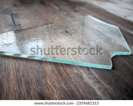 close up of pieces of broken glass shards on the surface of a wooden board