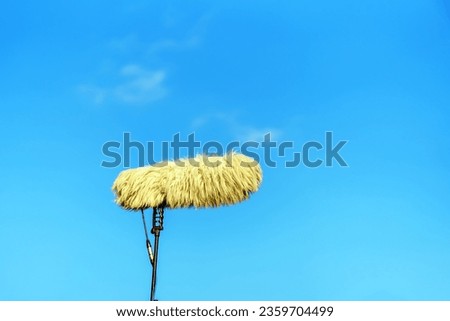 A large microphone is covered with a fur windproof nozzle against the sky Royalty-Free Stock Photo #2359704499