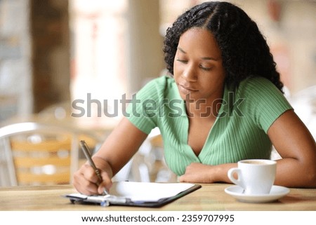 Black woman filling form or survey sitting in a bar terrace