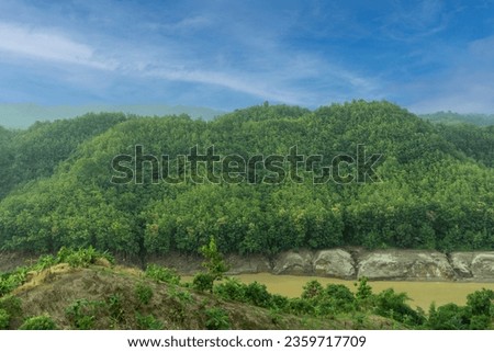 During the rainy season, the dense green hills blend into the blue sky. Sangu river flows below. Hilly region of Bandarban district of Bangladesh.