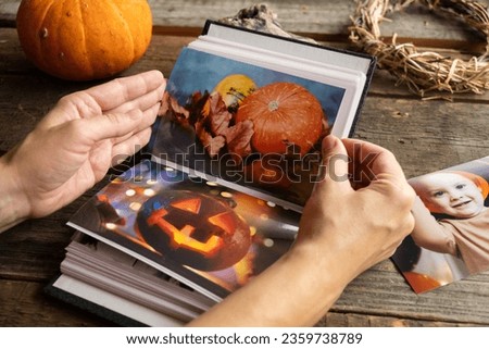 Halloween printed photos in photo album. Person browsing picture album.