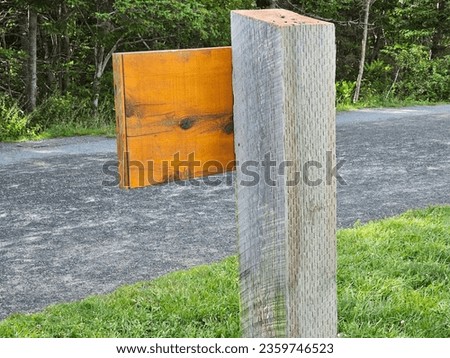 The back of a wooden post with a sign attached to it.