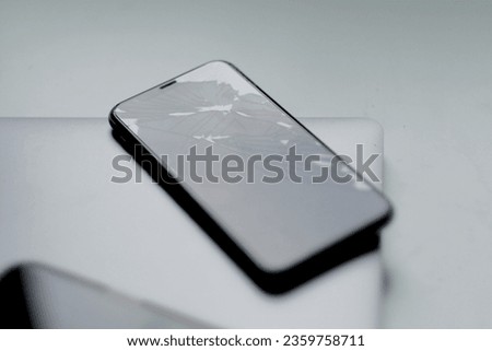 Brand new phone and phone with damaged display on table. Cracked screen. Out-of-order touchscreen. Warranty case. Royalty-Free Stock Photo #2359758711