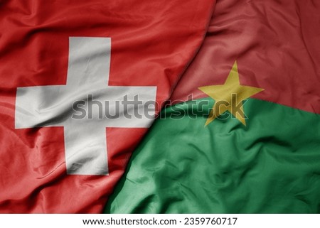 big waving national colorful flag of switzerland and national flag of burkina faso . macro