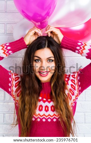 Close up fashion lifestyle image of young brunette woman with bright make up , amazing smile and long hairs holding pink path balloons. 