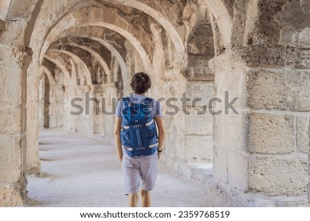 Man tourist explores Aspendos Ancient City. Aspendos acropolis city ruins, cisterns, aqueducts and old temple. Aspendos Antalya Turkey. turkiye Royalty-Free Stock Photo #2359768519