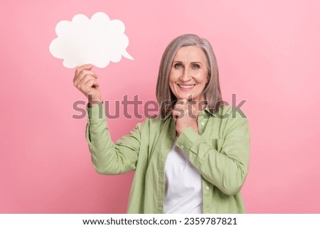 Photo of minded clever retired lady wear green stylish clothes demonstrate white paper card empty space isolated on pink color background