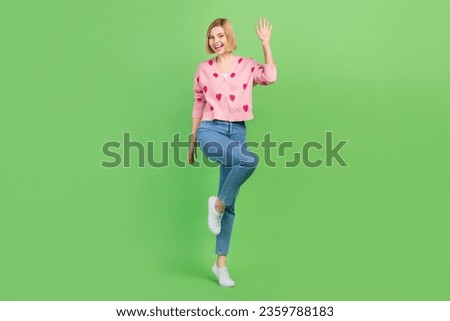 Full size photo of attractive woman waving hand hello dressed stylish pink strawberry print clothes isolated on green color background