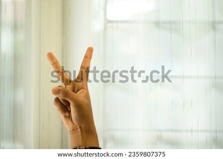 Right hand sign "two" hand gesture with white spacey background, as known as "peace", second
