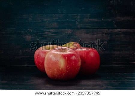 close up four apple fruit formation isolated black wood texture background 