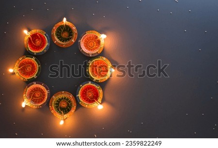 Happy Diwali - Clay Diya lamps lit during Diwali, Hindu festival of lights celebration. Colorful traditional oil lamp diya on blue background Royalty-Free Stock Photo #2359822249