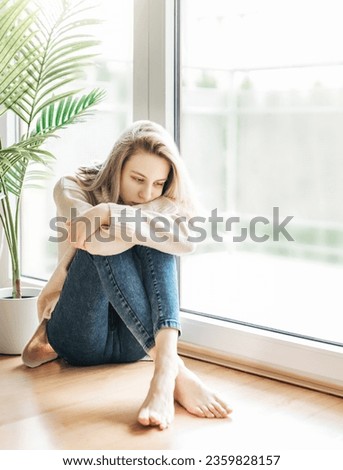 Sad girl near window thinking about something.  Stressed lady feel lonely
 Royalty-Free Stock Photo #2359828157