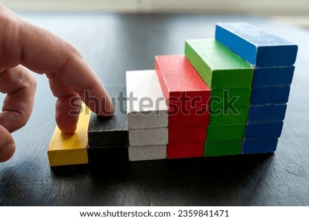 close up of businessman hand climbing upstairs on color wooden block, career ladder concept