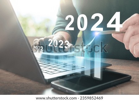 2024 new year. Business plan 2024 new year. Man working on laptop with growth chart 2024. Start new year 2024 with goal plan, goal concept, action plan, strategy, new year business vision. Royalty-Free Stock Photo #2359852469