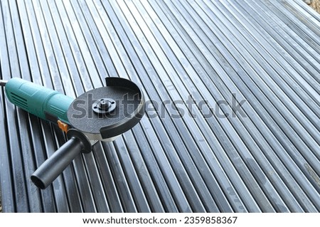 Angle grinder on metal pipes. Metal stripping. Preparing pipes for fence construction.