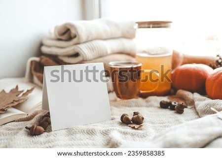 Empty card with place for your text, cup of tea and autumn decor.
