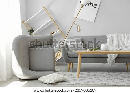 Sofa with table and armchair in messy living room Royalty-Free Stock Photo #2359886209