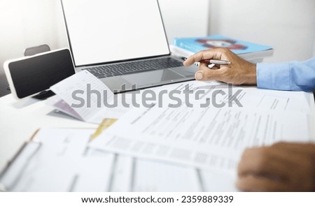 Businessman using laptop working and meeting online reviewing the loan documents and bank statement calculate the money in account before summarizing the results of the meeting and apply for a loan
