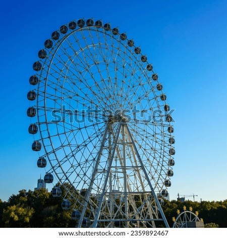 High ferris wheel at sunset or sunrise with blue sky background in an amusement park Navruz in Tashkent, Uzbekistan.