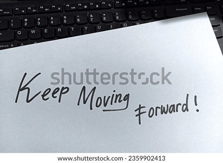Keep moving forward text written on white paper with a keyboard behind