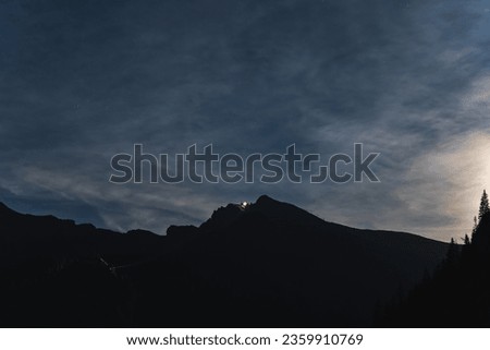 Night scene in the Polish Tatras. Mount Kasprov, cable road for the funicular, twilight and starry sky with a slight haze. High quality photo
