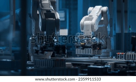 Modern EV Factory. On Automated Production Line Robot Arms Transporting Automotive Battery Modules onto Conveyor Belt. Electric Car Battery Pack Manufacturing Process. Royalty-Free Stock Photo #2359911533